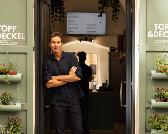 Restaurantbesitzer steht im Türrahmen